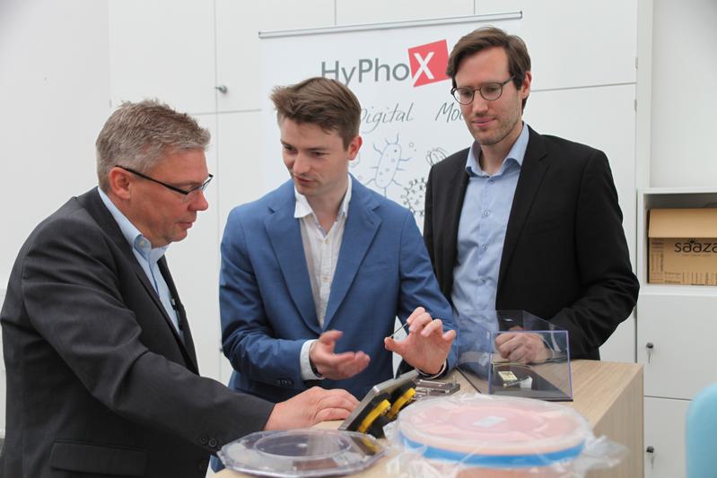 Kleine Mikrochips: Prof. Dr. Gerhard Kahmen (links) lässt sich von Dr. Martin Paul (Mitte) und Christoph Schumann die HyPhoX-Idee zur Analyse von Flüssigkeiten erläutern. 