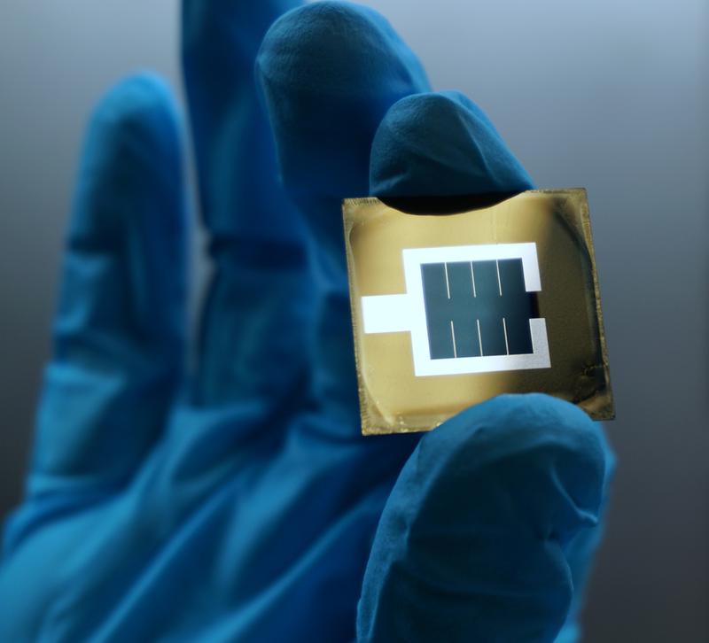 Foto der Perowskit/Silizium Tandem Solarzelle. Zu sehen ist die aktive bläuliche Fläche in der Mitte des Wafers, die von der metallischen, silbrigen Elektrode eingeschlossen wird.