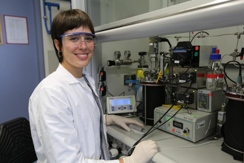 Paloma Garrido Amador next to the bioreactor setup, which has been housing the NO-respiring microorganisms for more than four years now in a lab in the Max Planck Institute for Marine Microbiology. 
