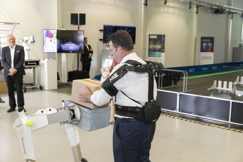 Für verschiedene Lagertätigkeiten testete der Minister die Hilfe eines Exoskeletts.