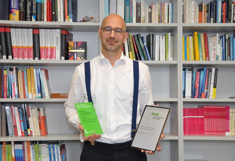 Professor Henning Rossa mit den alten - in gedruckter Broschüre - und neuen Bildungsstandards - im digitalen Format.