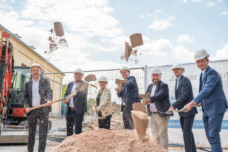 Beim Spatenstich buddeln gemeinsam Ulrich Delles, Hochschulkanzler Dr. Matthias J. Kaiser, Heidrun Piwernetz, Dominik Sauerteig, MdB Jonas Geissler, Prof. Dr. Stefan Gast, Prof. Dr. Jens Grubert. 