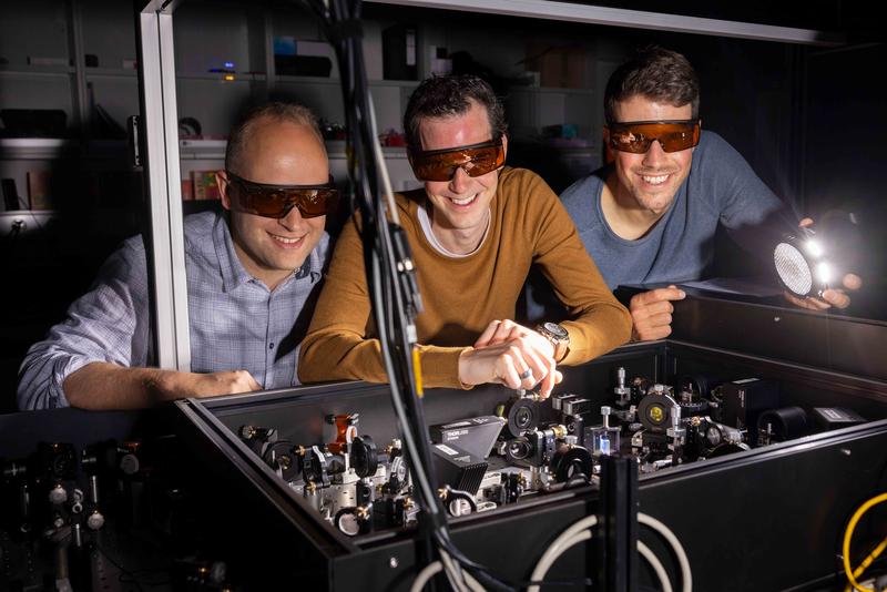 Lysander Huberich (links), Teamleiter Bruno Schuler (Mitte) und Optik-Spezialist Jonas Allerbeck an der THz-Optik, die Pikosekunden-genaue Anregungimpulse liefert. 