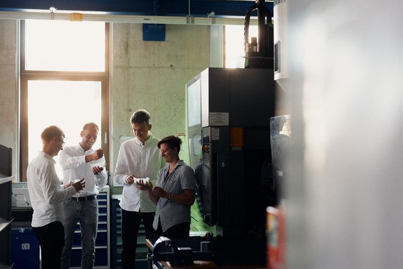 v.l. Jon Scherf, Fynn Zierenberg, Bennet Arndt und Kathrin Lahner diskutieren das Fertigungsergebnis des automatisiert spritzgegossenen Kastens aus Polypropylen. 