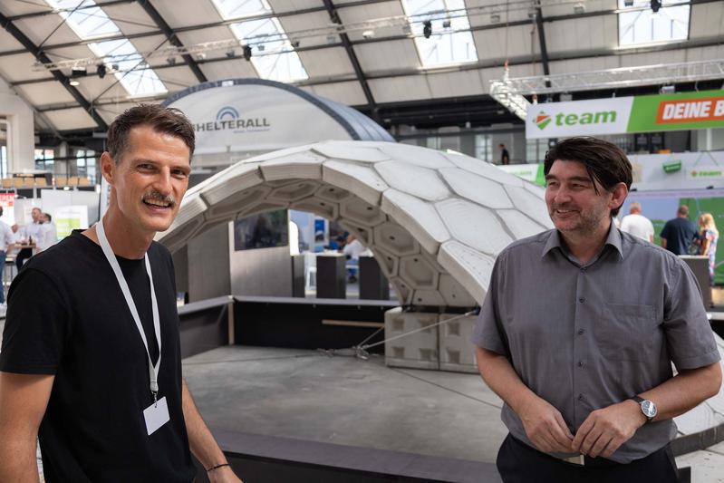 Die Professoren Michael Herrmann und Benjamin Spaeth vor der Beton-Schalenkonstruktion, die Studierende unter ihrer Betreuung entwickelt haben. Foto: TH Lübeck 