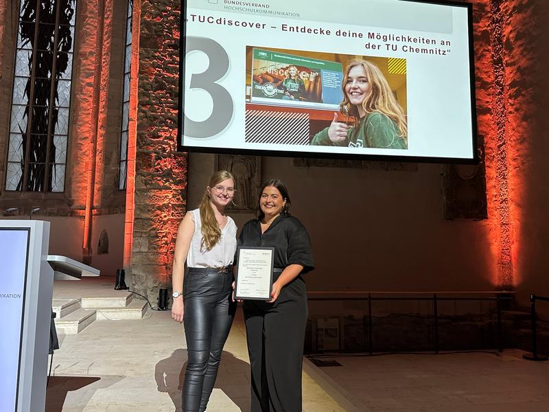 Susann Kappler (r.) und Angelina Wettinger nahmen den "Digital Award" des Bundesverbandes Hochschulkommunikation für das Projekt „TUCdiscover – Entdecke Deine Möglichkeiten an der TU Chemnitz“ entgegen. 