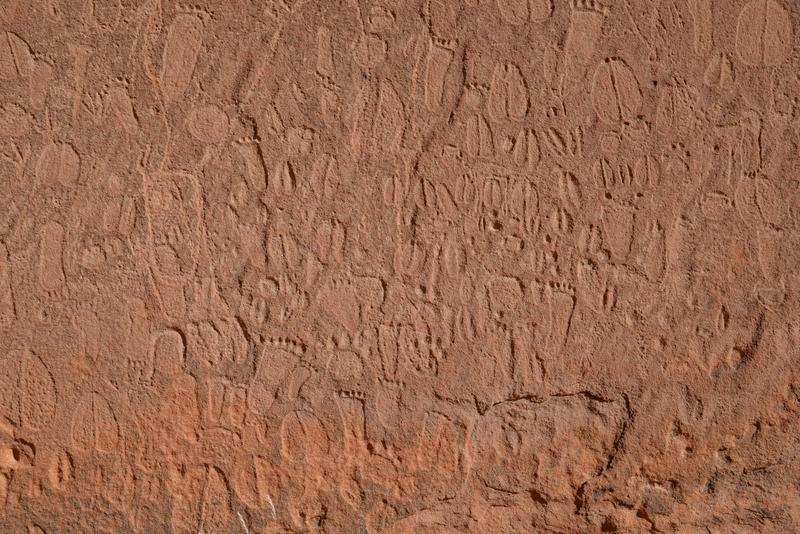 Detail von steinzeitlichen Darstellungen von menschlichen Fußabdrücken und Tierspuren in den Doro !nawas Bergen, Namibia.