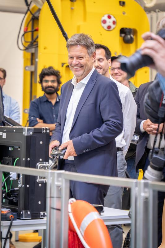 Robert Habeck steuert einen Unterwasserroboter durch das große Salzwasser-Testbecken der Maritimen Explorationshalle.