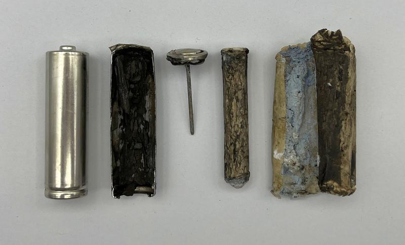 Bestandteile einer AA-Batterie: 1 - Metallbecher (Pluspol); 2 - Mangandioxid (Kathode); 3 - Ableitnagel (Mi-nuspol); 4 - Separator (Zellstoff und Bindemittel); 5 - Zinkpulver-Gel (Anode)