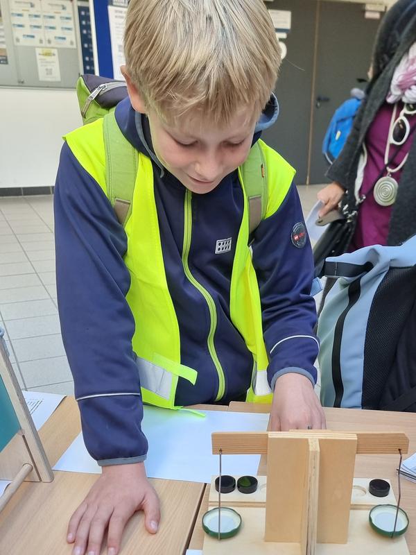 Ein junger Besucher beim Experimentieren mit Gewichten