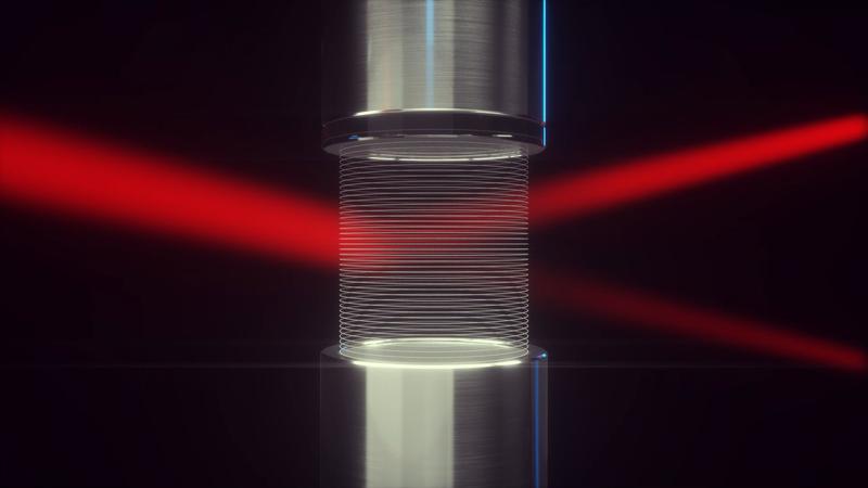 Ein Laserlichtstrahl läuft zwischen einer Lautsprecher-Reflektor-Anordnung hindurch, die ein Gitter aus Luft erzeugt. Der Laserstrahl interagiert mit diesem Gitter und wird berührungslos abgelenkt.