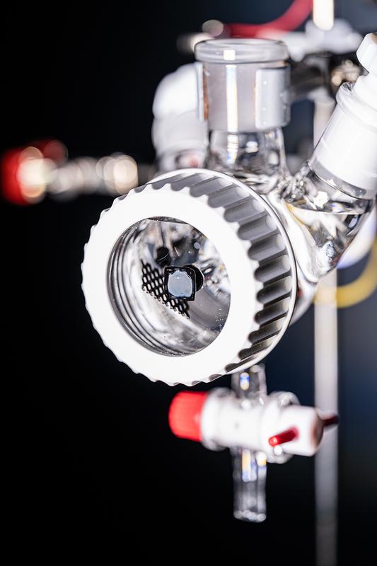 Die photoelektrochemische Schlenk-Zelle im Sonnensimulator.  Die rechteckige, graue Fläche mit schwarzer Einrahmung im Vordergrund ist die photoelektrochemische Solarzelle. © Valentin Marquardt / Universität Tübingen