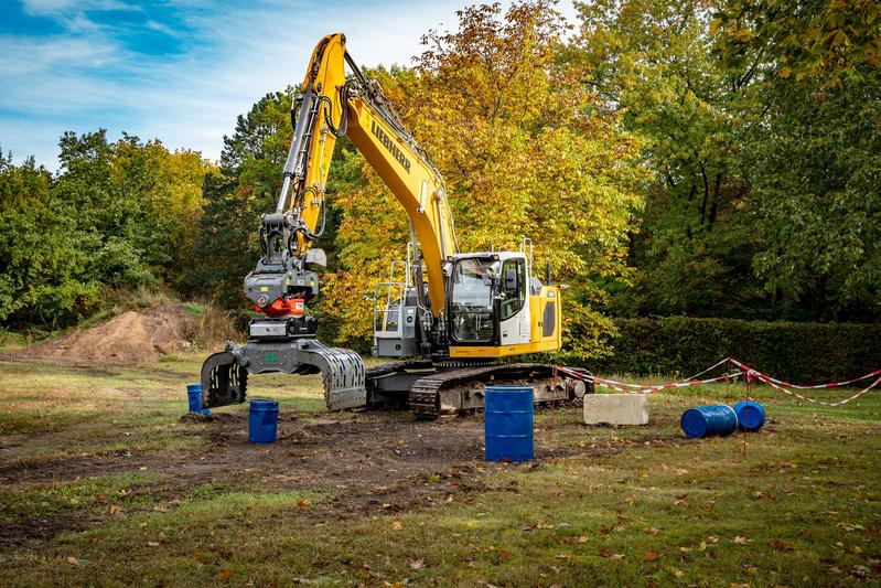 Autonomer Bagger beim Greifen von Fässern