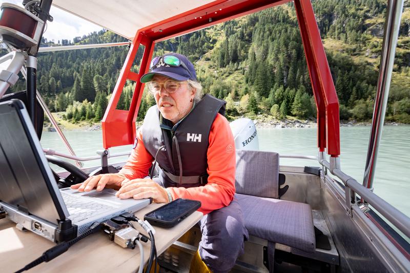 Florian Haas checks the data from the echo sounder on the computer during the survey trip. 