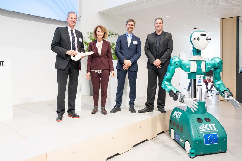 Schlüsselübergabe (v. l. n. r.): Prof. Oliver Kraft (KIT), Ursula Orth (VBA), Prof. Rafael Lang (KTS), Architekt Sven Bachmann, ARMAR-6. (ausführliche Bildunterschrift am Textende; Foto: Amadeus Bramsiepe, KIT)