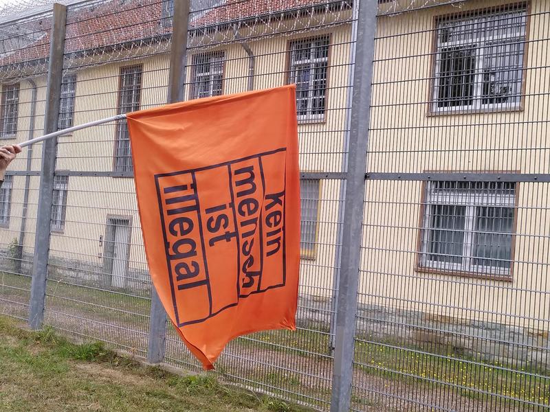 Flagge mit Slogan bei Demonstration vor Abschiebegefängnis