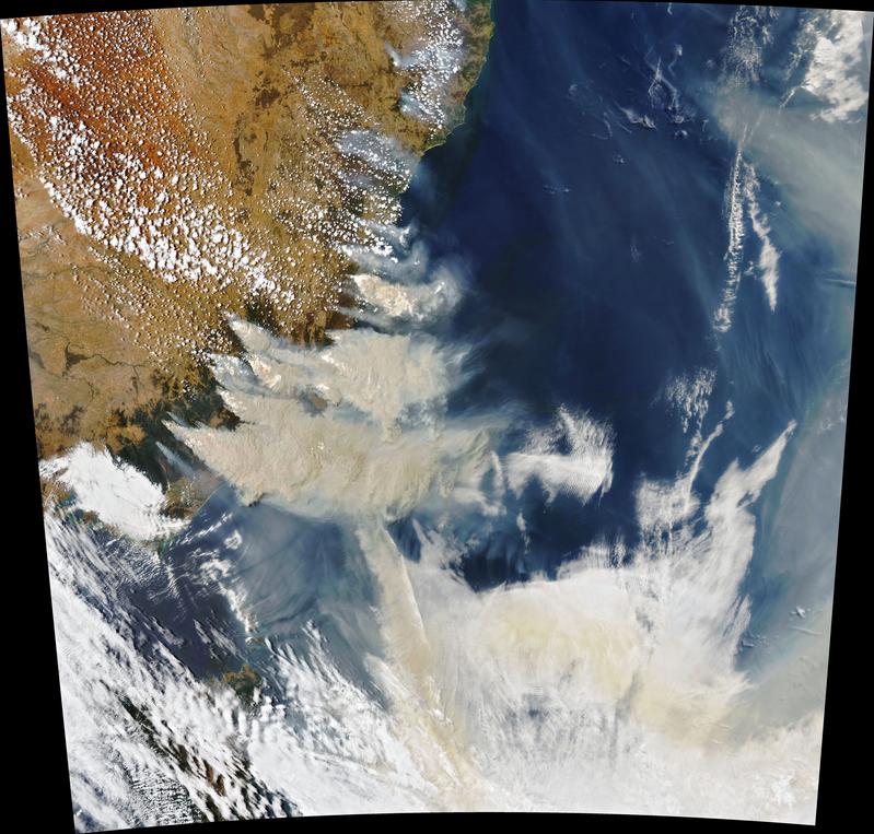 Satellitenbild des Südosten Australiens vom 4. Januar 2020 – aufgenommen mit dem Moderate Resolution Imaging Spectroradiometer (MODIS) des Aqua-Satelliten der NASA. Der Rauch hat eine hellbraune Farbe, während die Wolken strahlend weiß sind. 