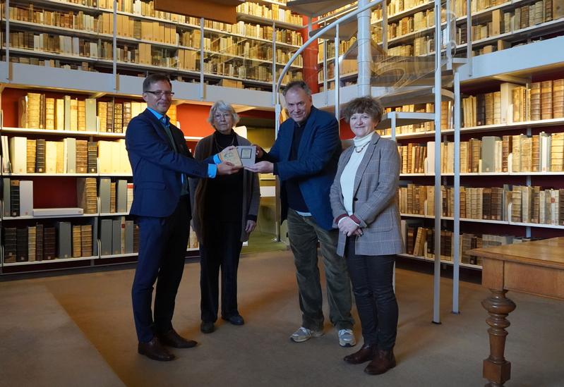 Johannes Mangei, HAB (links), übergibt die beiden Bücher an Adam Ganz (3. v. links), in Anwesenheit von Nicolette Mout, Witwe von Peter Felix Ganz (2. v. links) und Nathalie Neumann, Johannes-Gutenberg-Universität Mainz (rechts)