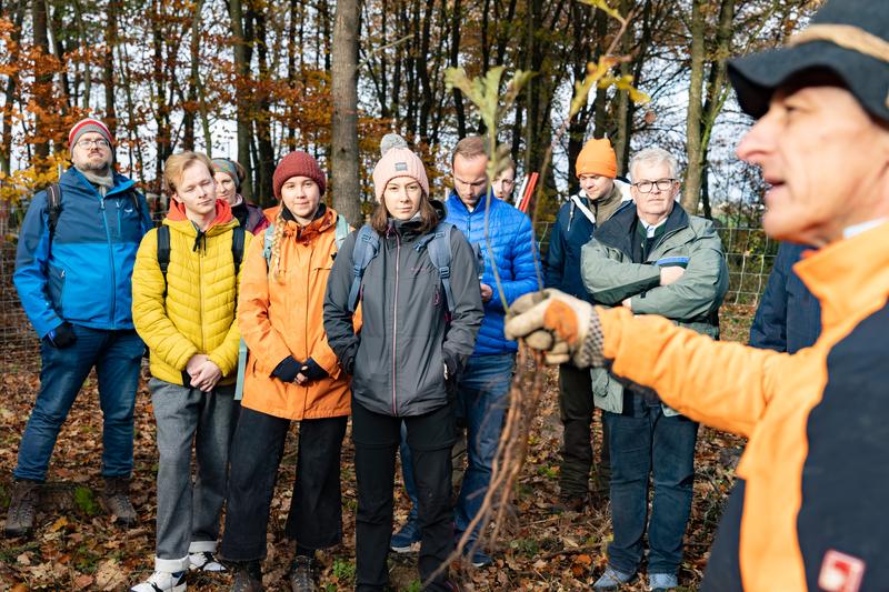 Forstwirtschaftsmeister Andreas Böhm erläuterte den Helferinnen und Helfern, was beim Pflanzen der Zöglinge zu beachten ist, damit sie zu kräftigen Bäumen heranwachsen können.