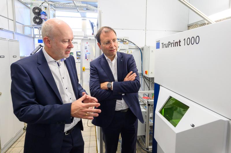 Im Anschluss an die Vertragsunterzeichnung führte Rektor Prof. Dr. Harald Riegel (links) Richard Bannmüller, Vorsitzender Geschäftsführer der Trumpf Laser und Systemtechnik GmbH, durch die Labore der Hochschule Aalen, wie hier im LaserApplikationsZentrum.