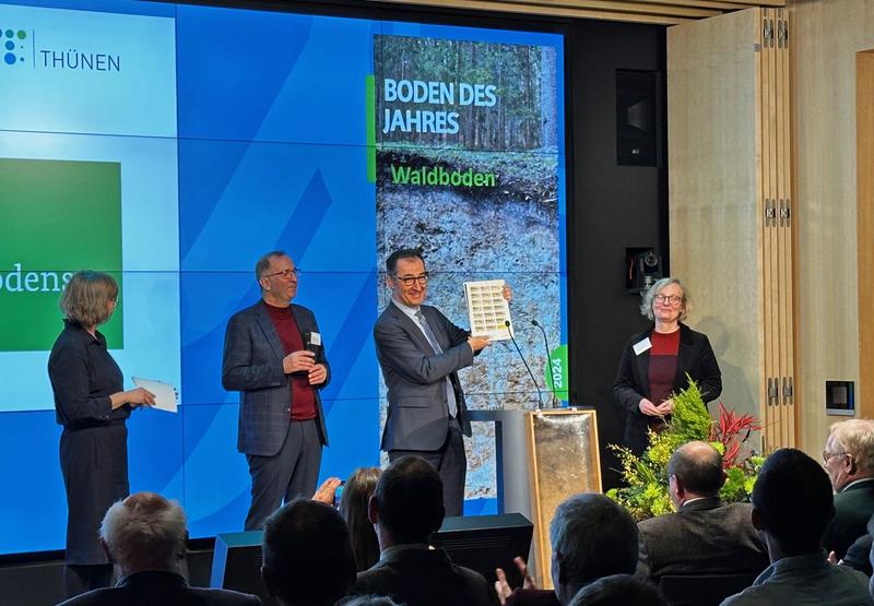 Bundesminister Cem Özdemir präsentiert die aktuelle Sonderbriefmarke zum Waldboden als Boden des Jahres.
