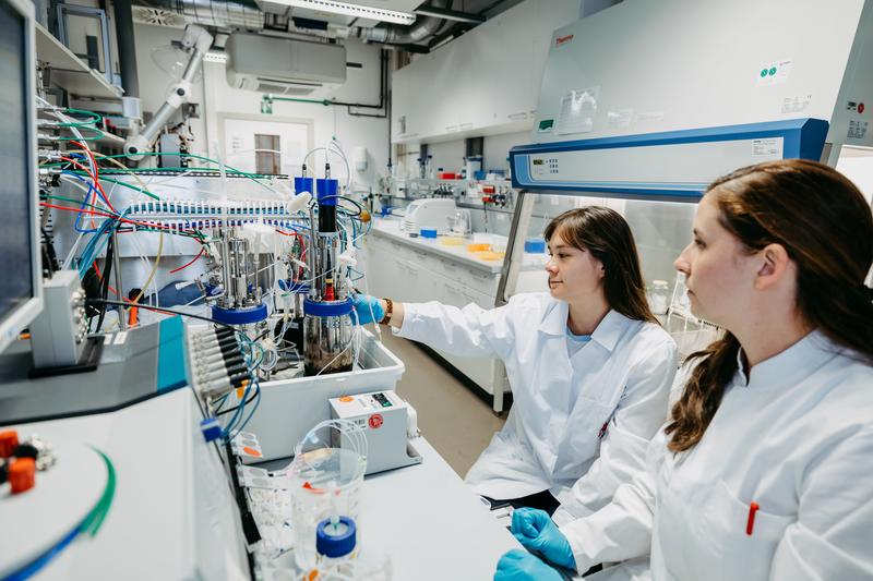Stefanie Duvigneau (rechts) und Anna-Sophie Neumann (links) arbeiten gemeinsam im Labor an der Biopolymerproduktionsanlage. 
