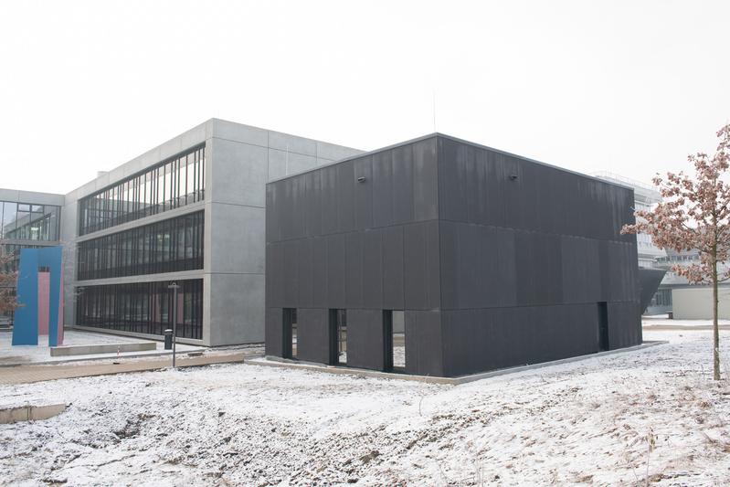 Das neue, anthrazitfarbene S3-Labor (rechts) steht auf dem Campus der Uni Ulm direkt hinter dem Zentrum für Quanten- und Biowissenschaften auf dem Campus der Uni Ulm