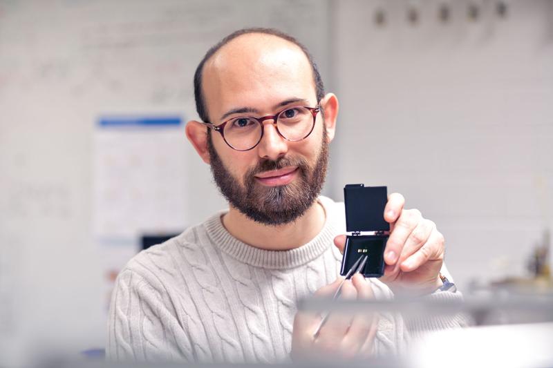 Lorenzo Tesi, showing two prototypes of metasurfaces he developed for the investigation of molecular spin qubits at terahertz frequencies.
