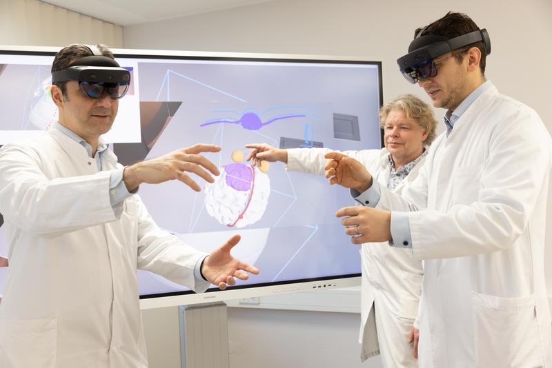 Dank der 3D-Datenbrille, die derzeit von der Arbeitsgruppe um Prof. Dirk Winkler (Mitte, hinten) entwickelt wird, können die Neurochirurgen Prof. Erdem Güresir (li.) und Dr. Johannes Wach die sogenannte „erweiterte Realität“ bei ihrer Arbeit nutzen.