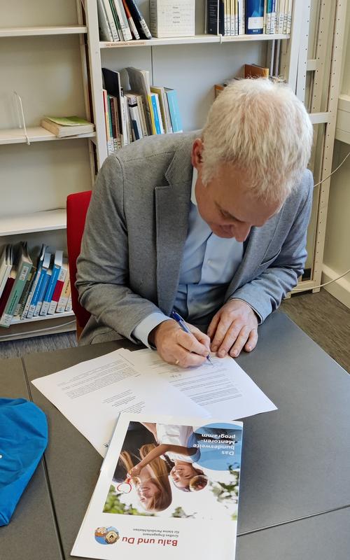 Dr. Dominik Esch, Vorstandsvorsitzender bei Balu und Du e.V., unterschreibt den Vertrag mit der Deutschen Sporthochschule Köln.