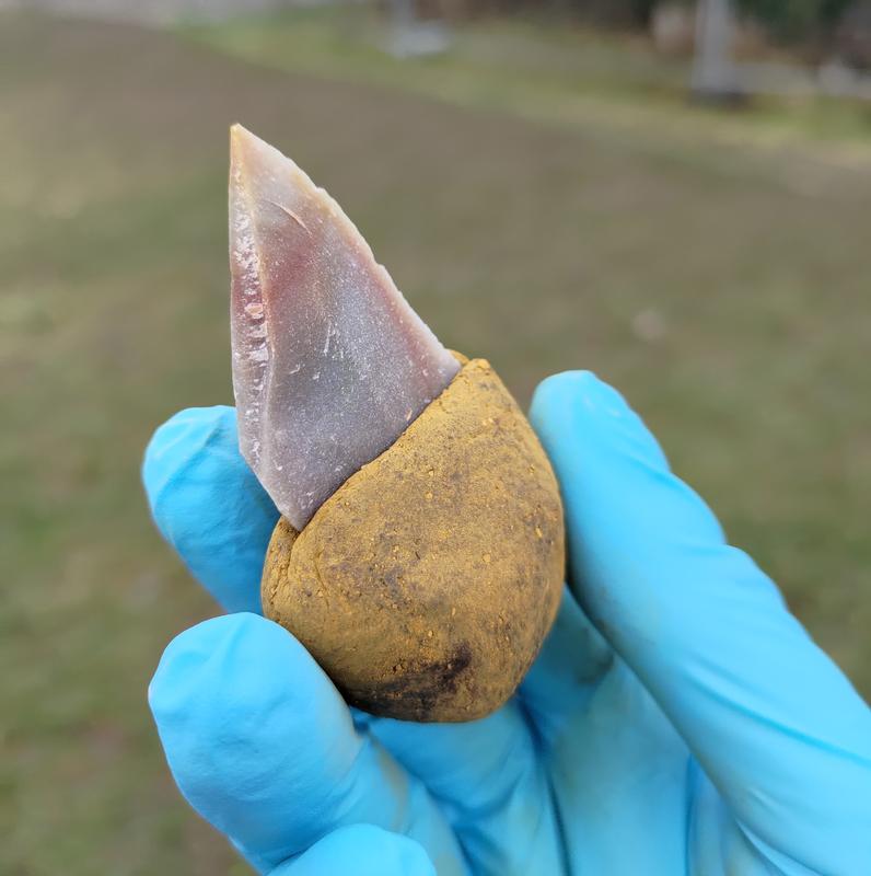 Experiment reproducing a bitumen-based compounds adhesive: The stone tool was glued into a handle made of liquid bitumen with the addition of 55 percent ochre. It is no longer sticky and can be handled easily.