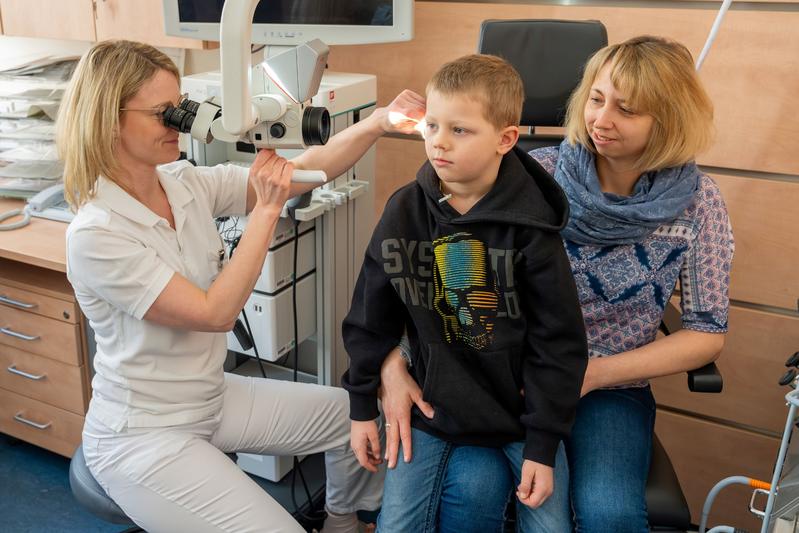 Dr. Susen Lailach (l.) kontrolliert regelmäßig im HörCentrum des Uniklinikums Dresden die Hörsysteme von Charly und seiner Mutter Marie Holtzsch.