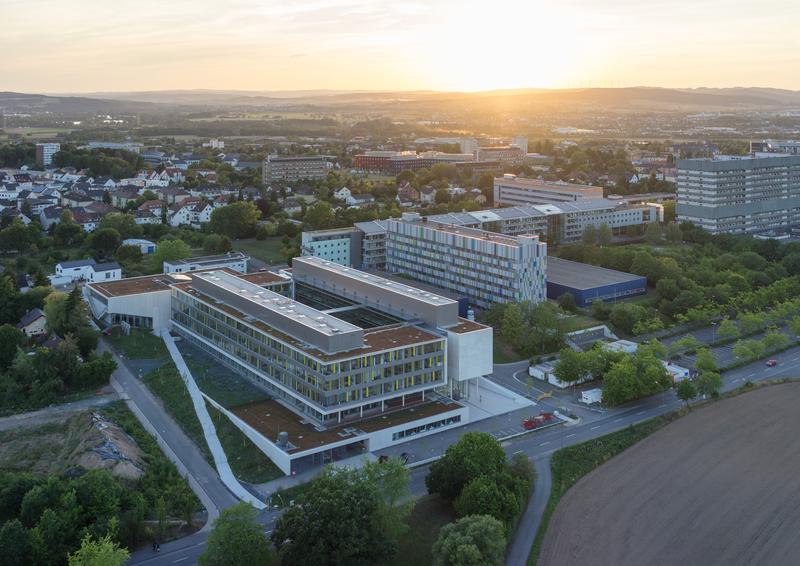 Campus Natur- und Lebenswissenschaften der JLU mit dem schmalen, grau-bunten Physikgebäude in der Bildmitte. 