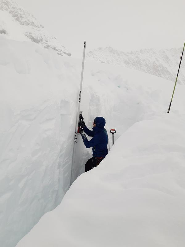 SLF snow physicist Lars Mewes creates a snow profile in poor visibility.