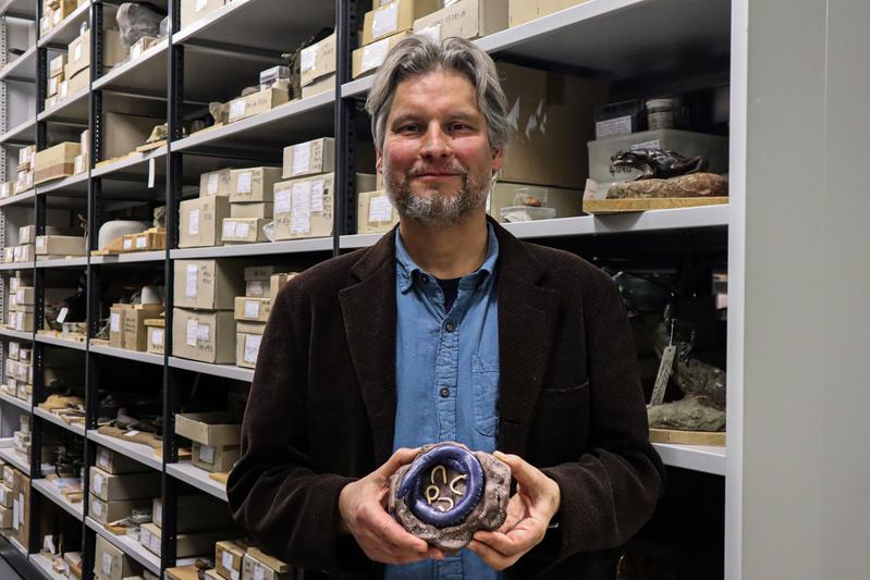 Dr. Alexander Kupfer mit einem Schleichenlurchmodell mit Jungen in den Sammlungen des Naturkundemuseums Stuttgart.