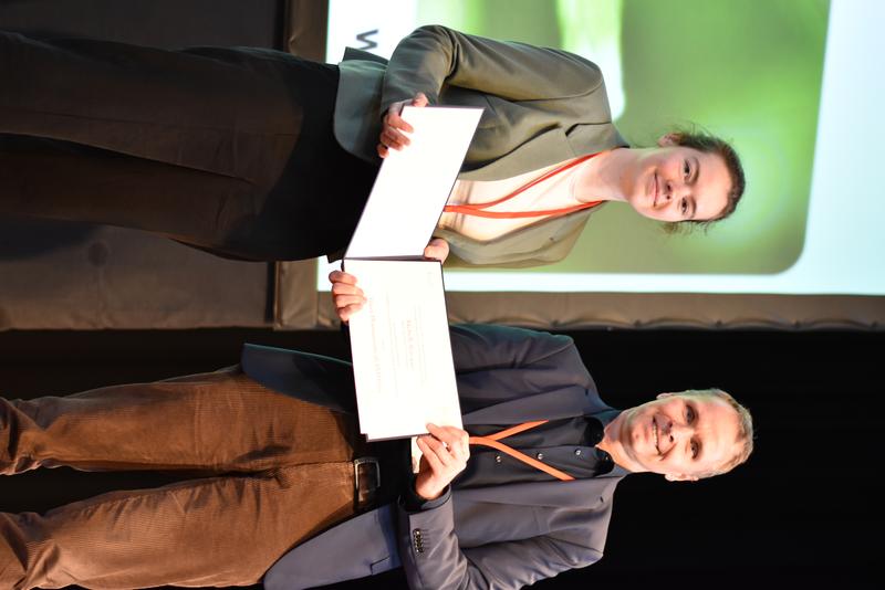 GBM-Präsident Volker Haucke überreicht die Urkunde zum Bayer Pharmaceuticals Promotionspreis an Michelle Rönspies.