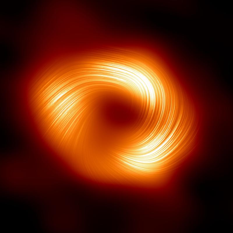 Event Horizon Telescope: Blick auf das Schwarze Loch im Zentrum der Milchstraße in polarisiertem Licht. Die Linien markieren die Ausrichtung der Polarisation, die mit dem Magnetfeld um den Schatten des Schwarzen Lochs zusammenhängt.