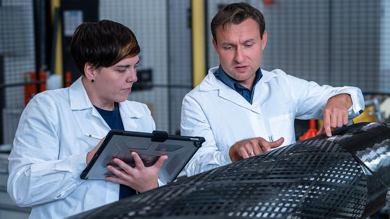 Claudia Vogt und Dr. Mario Naumann vom Forschungsbereich „Carbonfaser- und Verarbeitungstechnologien“ untersuchen einen im Herstellungsprozess befindlichen rotationsförmigen carbonfaserverstärkten Leichtbaudruckbehälter im Faserverbundlabor.