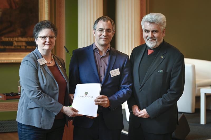 Rektorin Claudia Becker und Jonathan Everts erhalten den Förderbescheid von Minister Armin Willingmann.