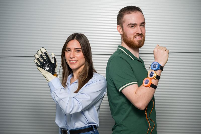 Doktorandin Sipontina Croce und Student Lukas Roth (r.) forschen an Folien, die Textilien neue Fähigkeiten verleihen. Smarte Arbeitshandschuhe werden ebenso möglich wie smarte „Uhren“, die virtuelle Berührungen spürbar machen.