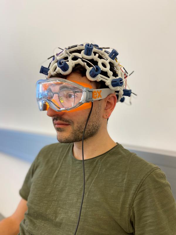 Alessandro Venturino mit einem frühen Prototyp. Der Neurowissenschafter zeigt die Anwendung des brillenähnlichen Geräts von Syntropic Medical. 