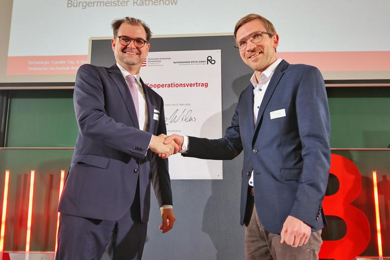 Mit ihrer Unterschrift und einem Handschlag besiegelten THB-Präsident Prof. Dr. Andreas Wilms und Andi Köpke als Geschäftsführer der Rathenower Optik GmbH die neue Kooperation auf der Bühne des Audimax der THB.