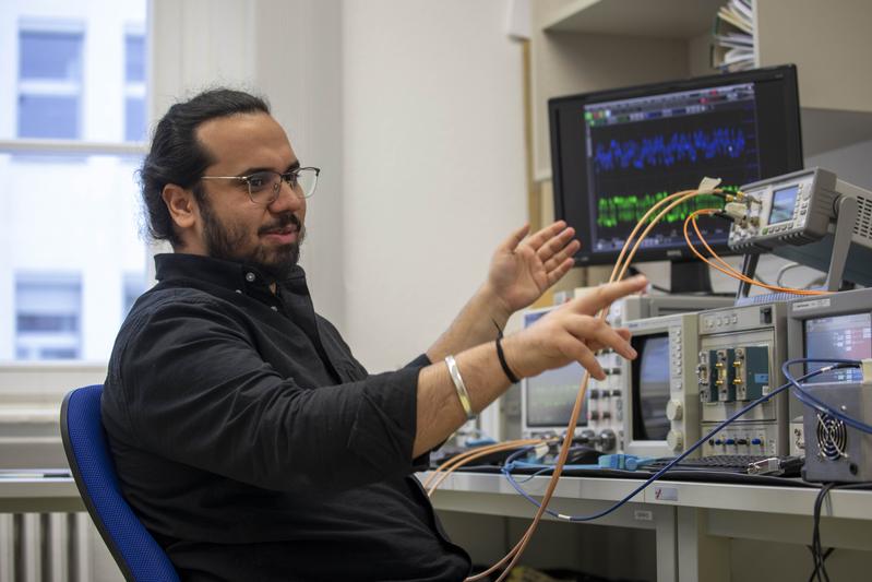 Jasmeet Singh erläutert im Labor für Lichtwellenleitertechnik des Bereiches Elektrotechnik und Informatik seinen Versuchsaufbau zum praktischen Test, der von ihm entwickelten Algorithmen.