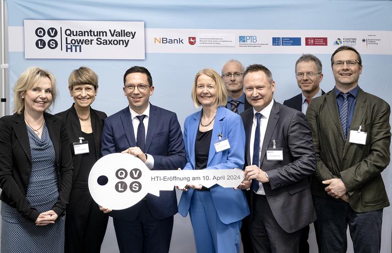 Prof. Dr. Sabine Döring (BMBF), Prof. Dr. Angela Ittel (TU BS), Minister Falko Mohrs, Prof. Dr. Cornelia Denz (PTB), Michael Kiesewetter (NBank), Dr. Nicolas Spethmann. Hinten: Dr. Piet Schmidt und Dr. Christian Ospelkaus.