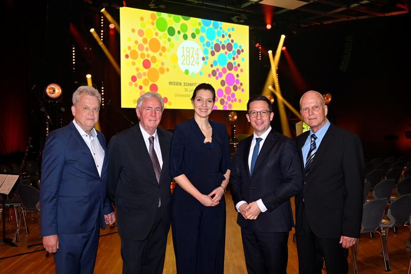 Die ehemaligen Universitätspräsidenten Prof. Dr. Lücke (links), Prof. Dr.-Ing. Rollinger (Zweiter von links), Prof. Dr. Künzel (rechts) mit der amtierenden Präsidentin Prof. Dr. Menzel-Riedl und dem Wissenschaftsminister Mohrs (Zweiter von rechts).