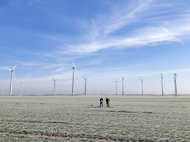 Zwei Forschende im Windpark in Nauen bei Berlin, wo sie im Februar 2023 die seismischen und weitere Messungen durchgeführt haben.  