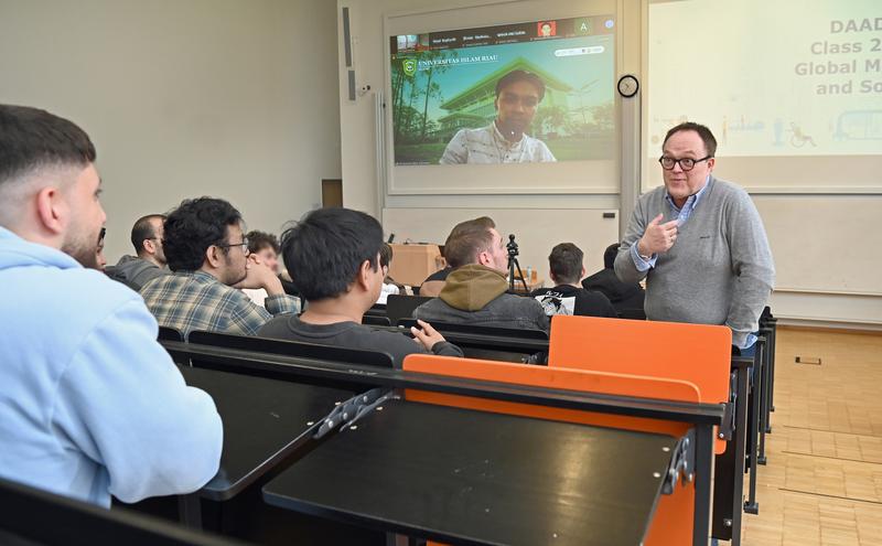 Prof. Dr. Michael Bohne (r.) vom Fachbereich Wirtschaft an der FH Dortmund und Muhammad Akbar Almuttaqin von der Universitas Islam Riau (auf der Leinwand zugeschaltet) unterrichten gemeinsam. 