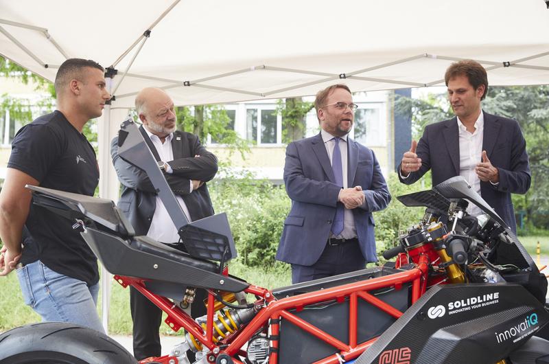 Wissenschaftsminister Timon Gremmels (Zweiter v.r.) am studentischen Elektro-Sportmotorrad "Gauss II" mit h_da-Präsident Prof. Dr. Arnd Steinmetz (Zweiter v.l.), Prof. Dr. Jens Hoffmann (rechts) und Student Ali Kücük (links).