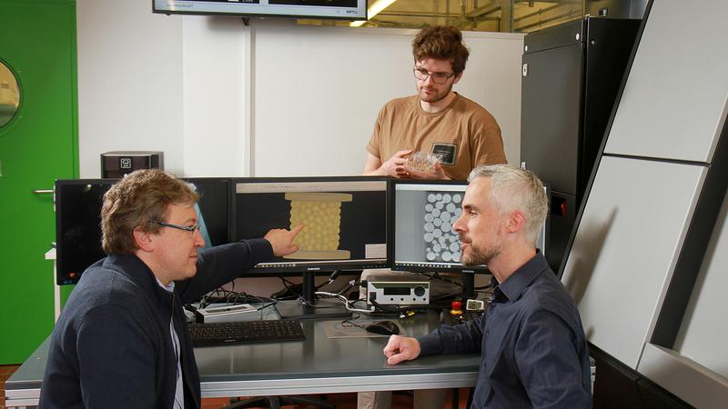 Prof. Sergiy Antonyuk (l.), Dr. Kai Nikolaus und Yannik Sinnwell (hinten im Bild) erforschen die mechanischen Eigenschaften von sogenannten Agglomeraten wie Tabletten. 