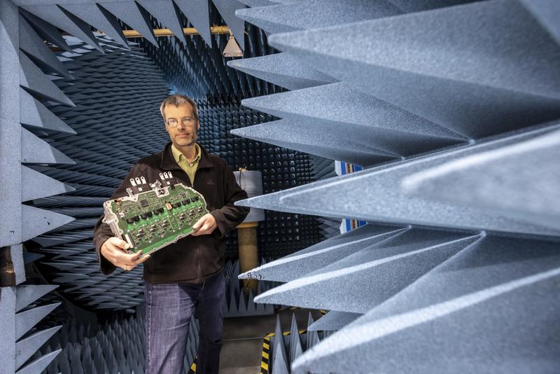 Jan Hansen with the power electronics of an electric motor in the antenna measurement chamber at TU Graz.